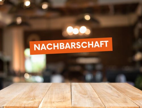 Der Text „Nachbarschaft“ steht in einem orangen Textblock. Im Hintergrund sind ein Holztisch und eine unscharfe Beleuchtung abgebildet.