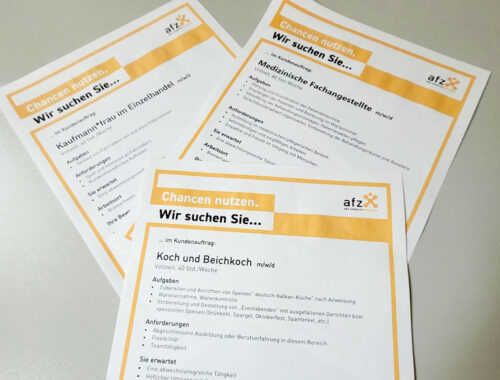 Drei Blätter mit Stellenangeboten aus Bremerhaven liegen auf einer Tischplatte. Die Stellenangebote werden von der Arbeitsförderungs-Zentrum im Lande Bremen GmbH zusammengestellt.