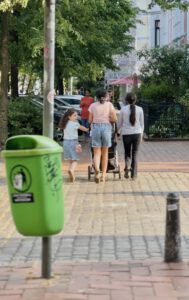 Drei Mädchen sind von hinten zu sehen und schieben einen Kinderwagen die Goethestraße entlang.