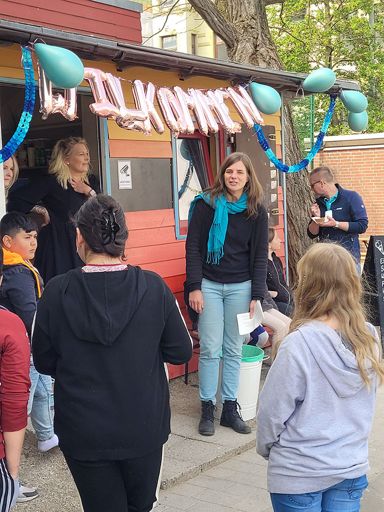 Miriam Gieseking, Quartiersmeisterin in Bremerhaven Lehe, hält eine kurze Rede vor Eltern und Kinder bei der Eröffnung der Bunten Bude auf dem Leher Pausenhof.