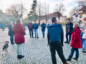Rundgang mit mehreren Personen durch das Goethequartier. Miriam Gieseking erzählt Fakten zur Geschichte Lehes. Im Hintergrund sieht man Häuser und Bäume.