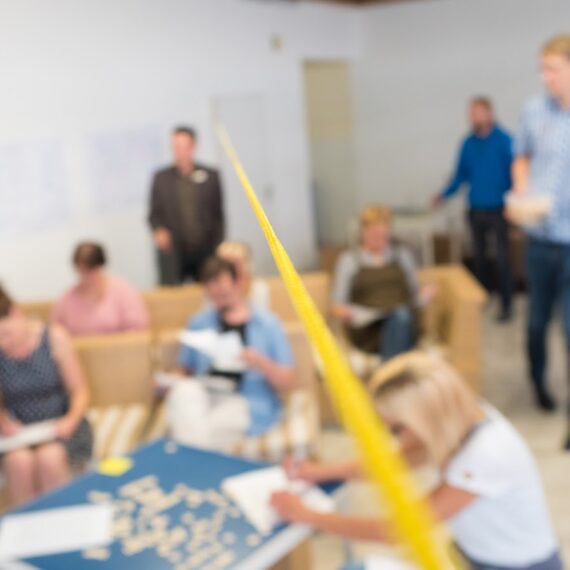 Menschen arbeiten bei der Veranstaltung „Workshop Ideenschmiede“ zusammen.