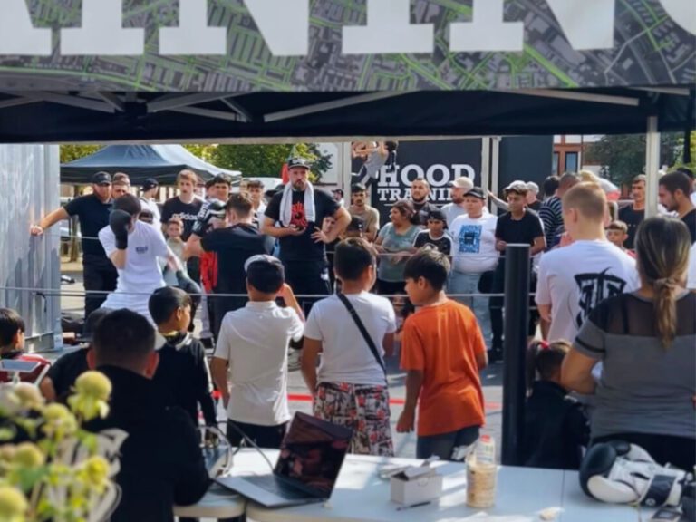 Kinder stehen draußen vor einem Boxring