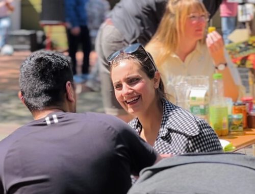 Menschen unterhalten sich und essen zusammen beim Straßenpicknick in Bremerhaven Lehe.