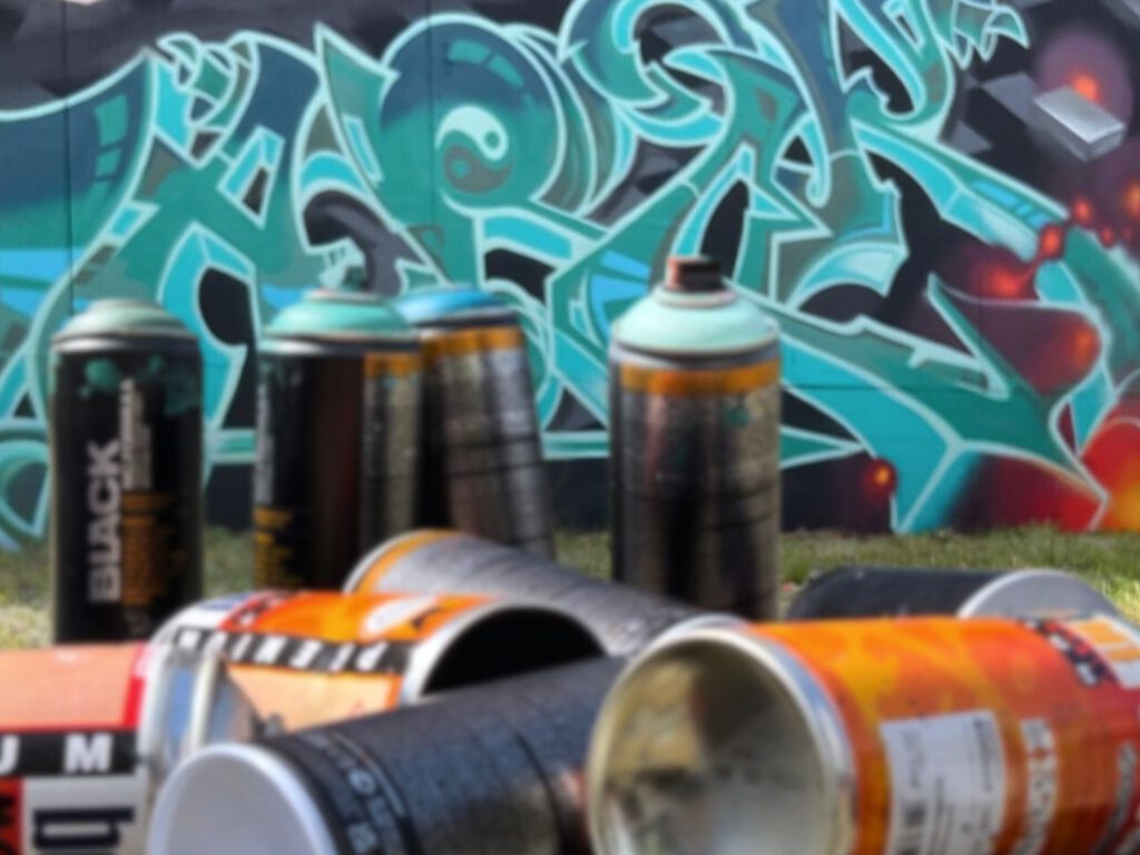 Graffiti Dosen vor einer bemalten Wand