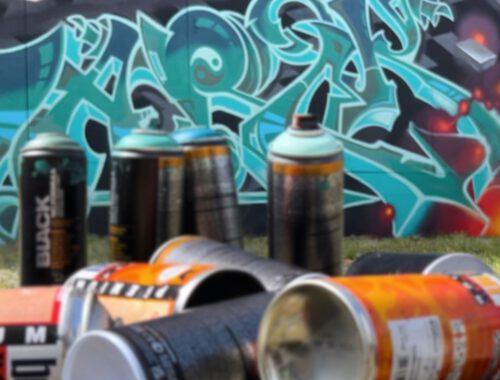 Graffiti Dosen vor einer bemalten Wand