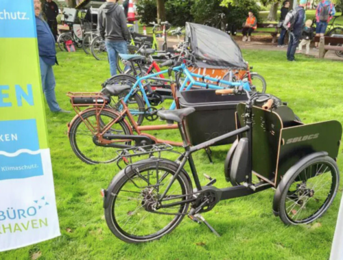 Mehrere Lastenräder stehen nebeneinander auf einer Wiese