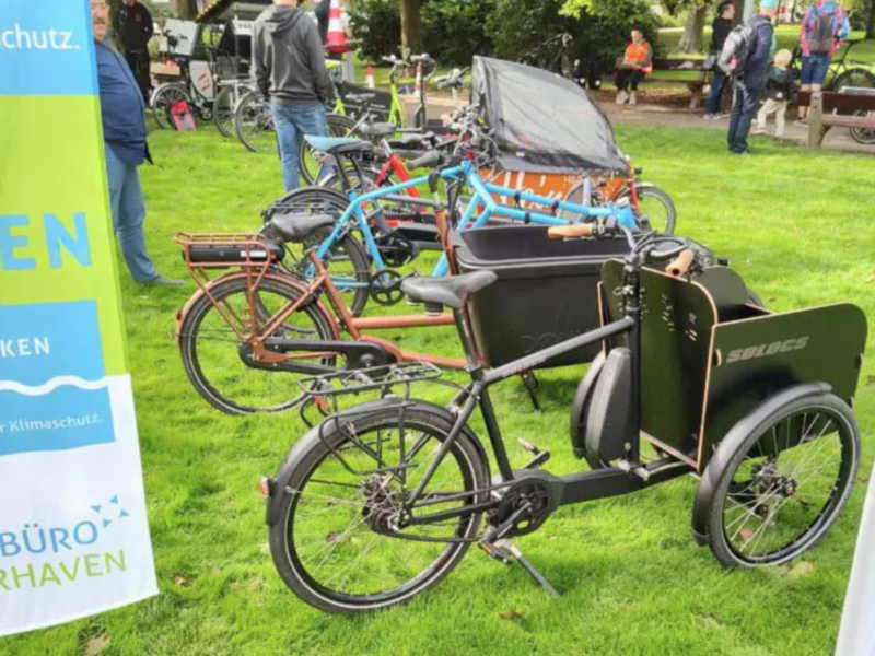 Mehrere Lastenräder stehen nebeneinander auf einer Wiese