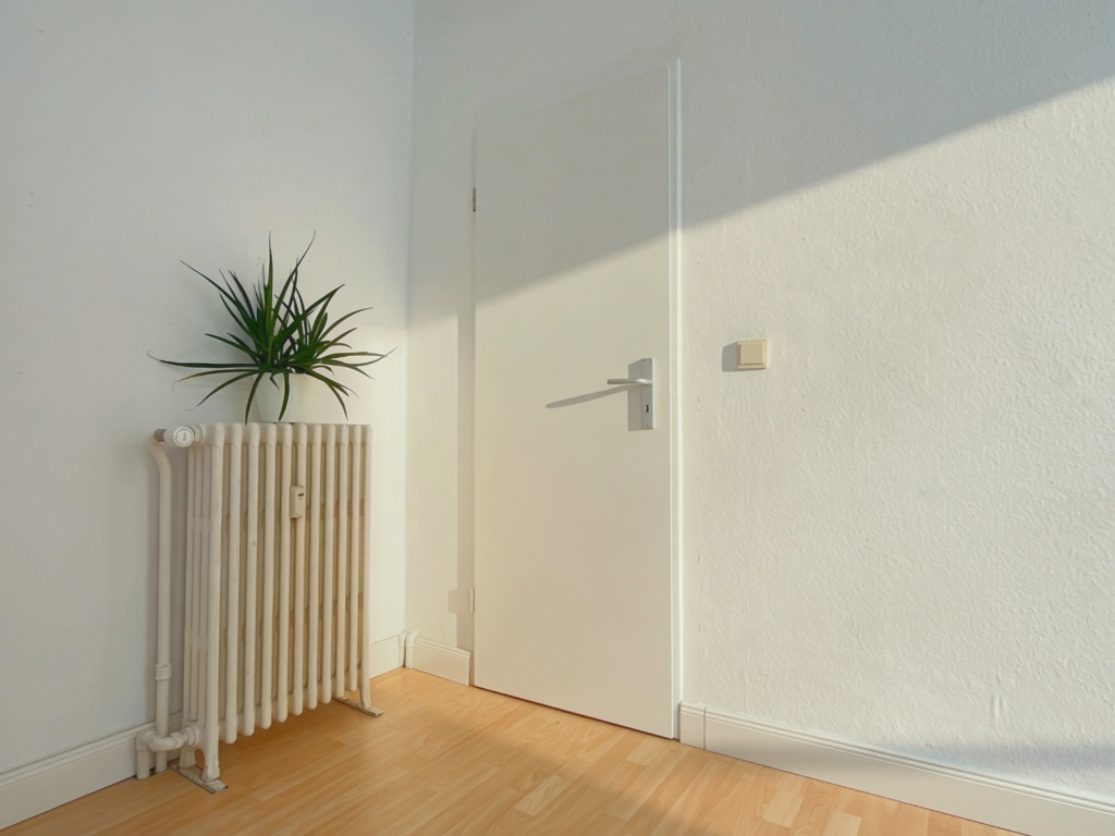 Ein leerer Raum mit einer Tür und einer Heizung
