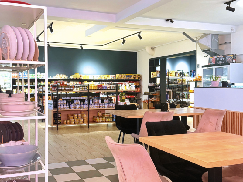 Cafetische mit Supermarktregalen im Hintergrund