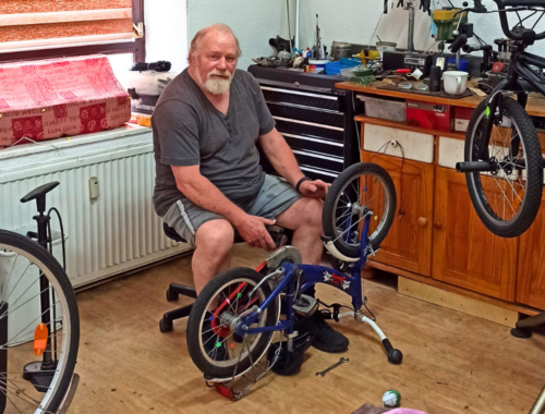 Fahrrad-Selbsthilfewerkstatt Rostlaube mit Betreiber Heinz Tebelmann bei der Reparatur eines Kinderfahrrads