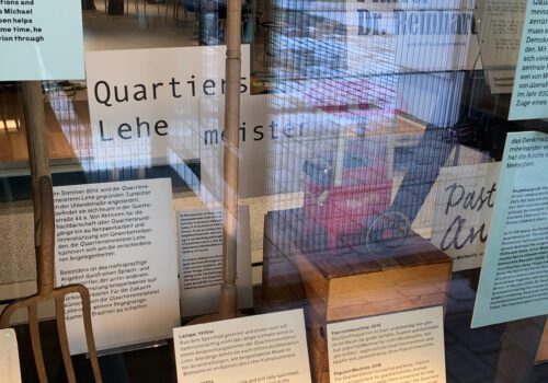 Verschiedene Infotexte der Ausstellung, sowie begleitende hinter einem Schaufenster