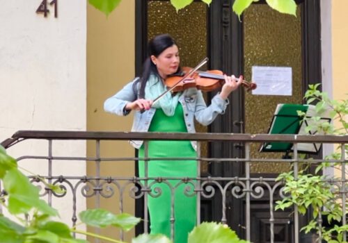 Eine Frau spielt Geige in einem Hauseingang