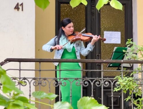 Eine Frau spielt Geige in einem Hauseingang