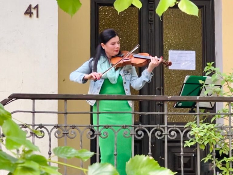 Eine Frau spielt Geige in einem Hauseingang
