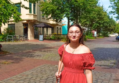Eine junge Frau in einem roten Kleid auf der Goethestraße