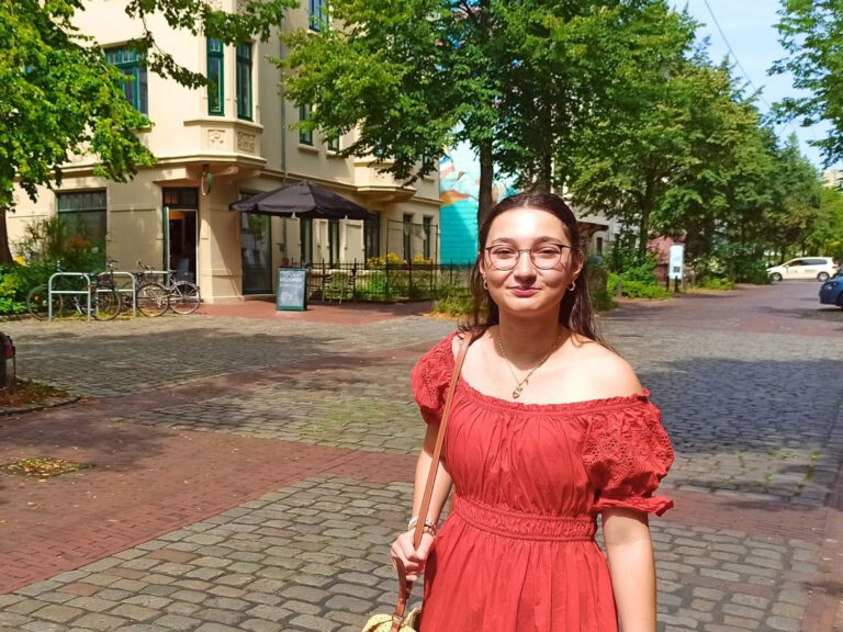 Eine junge Frau in einem roten Kleid auf der Goethestraße