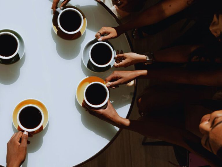 Menschen sitzen an einem Kaffeetisch