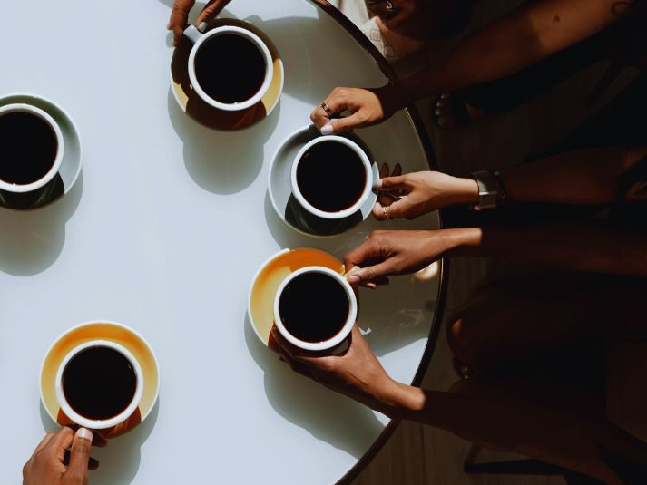 Menschen sitzen an einem Kaffeetisch