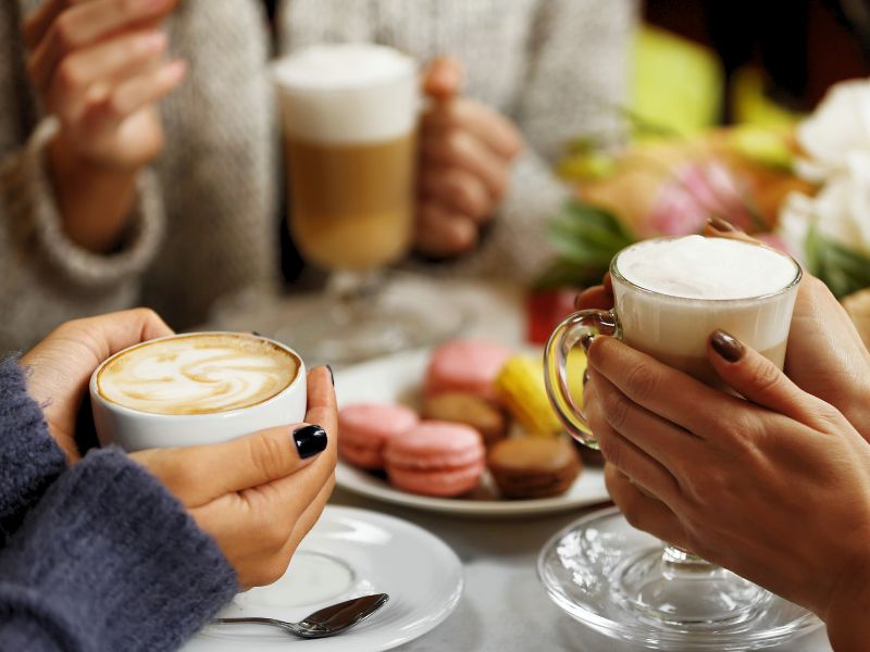 drei paar Hände halten Kaffetassen