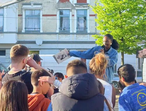 Eine Frau steht auf einer Bühne und rappt