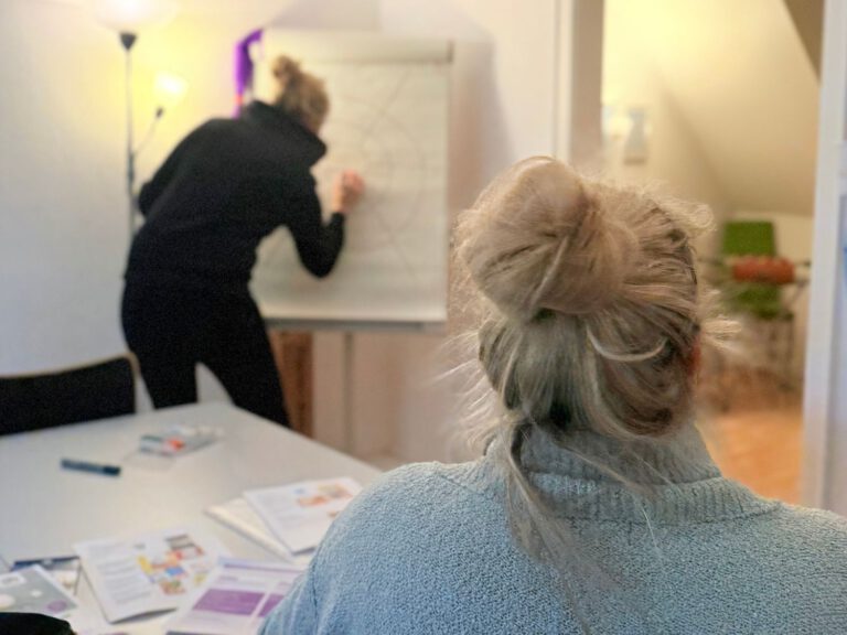die beiden Gesundheitsfachkräfte sind von hinten dabei zu sehen wie sie gerade einen Workshop vorbereiten