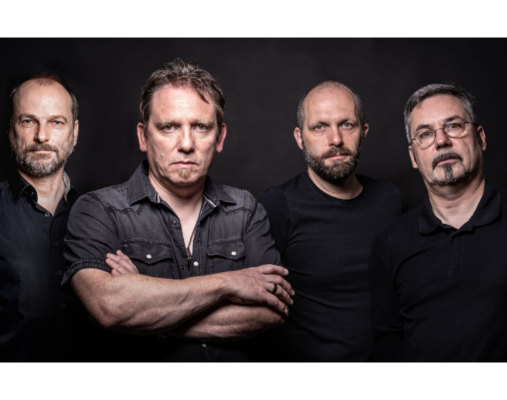 4 Bandmitglieder vor schwarzer Wand