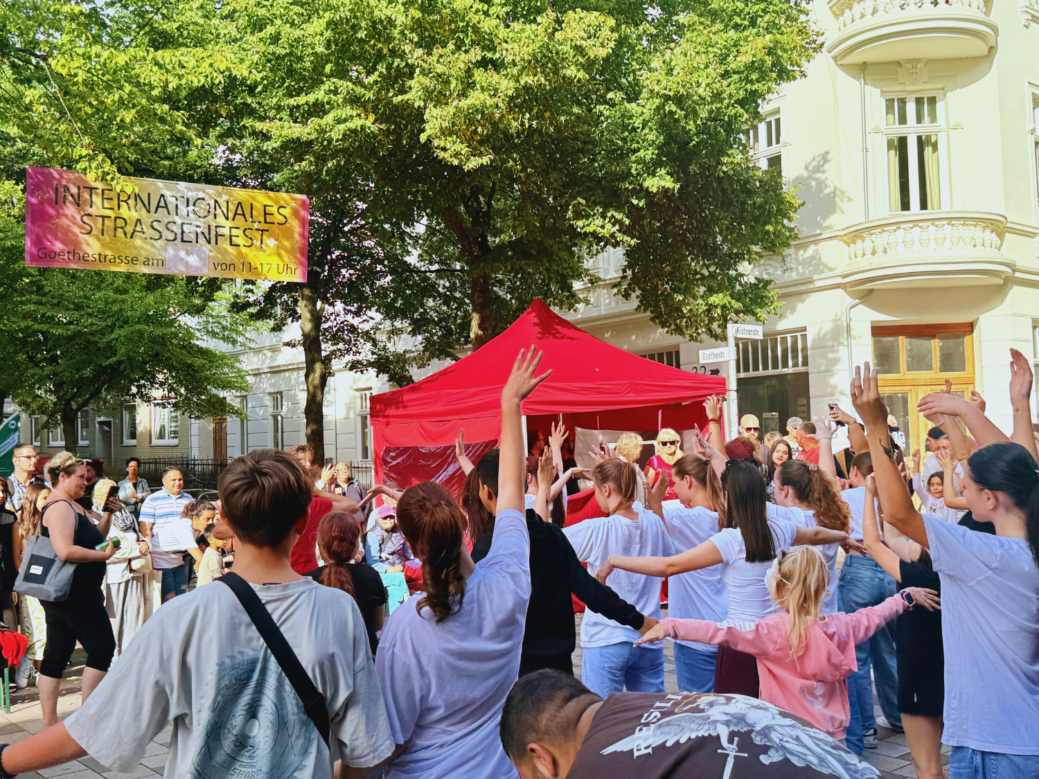 Menschen stehen auf einem Platz und tanzen
