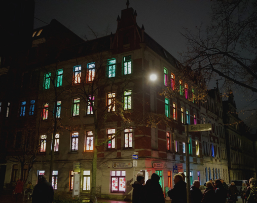Ein Haus mit bunt beklebten und beleuchteten Fenstern