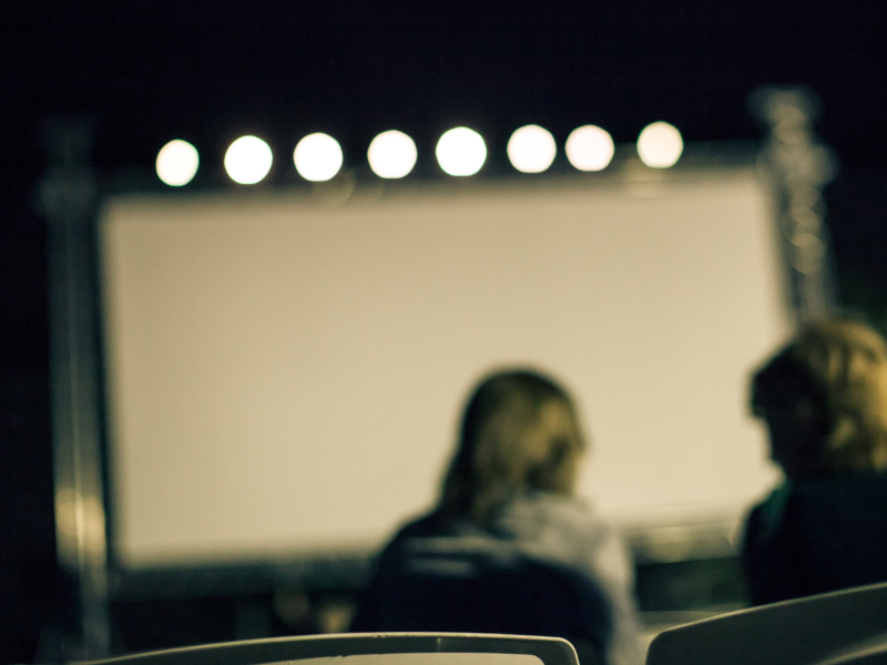 2 Menschen von hinten vor Kinoleinwand