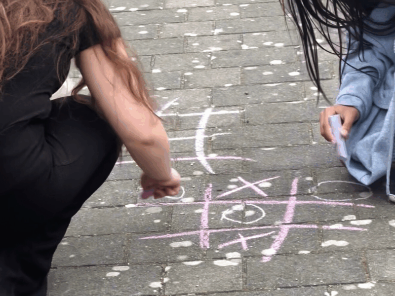 2 Jugendliche malen mit Kreide ein 