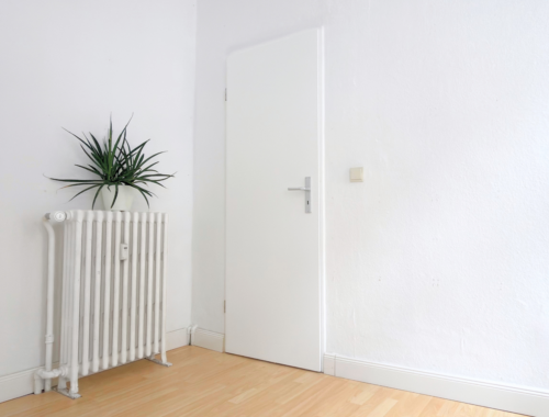 Ein leerer Raum mit einer Tür und einer Heizung