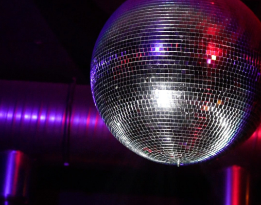 eine Discokugel in rot-lilanem Licht