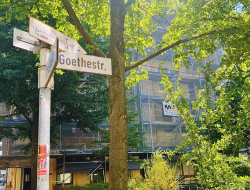 Das Goethestraßenschild vor grünen Bäumen