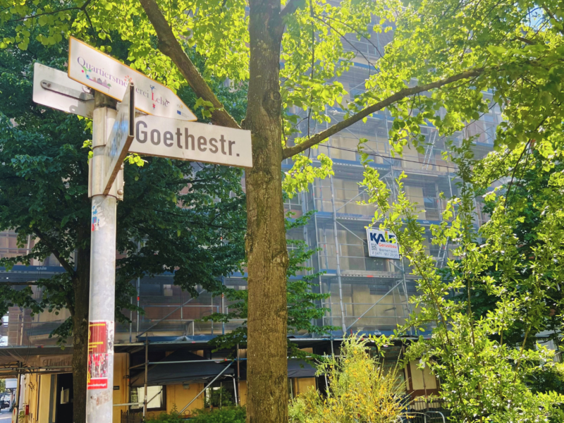 Das Goethestraßenschild vor grünen Bäumen