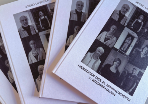 Mehrere Bücher mit Portraitfotos darauf sind übereinander gestapelt