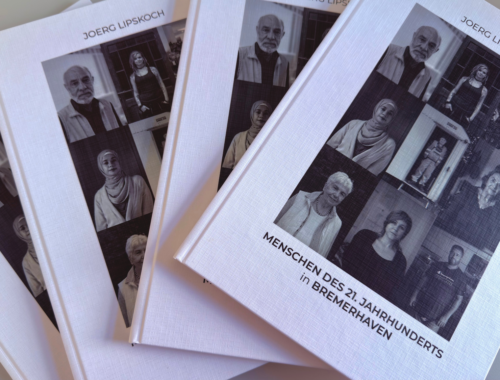 Mehrere Bücher mit Portraitfotos darauf sind übereinander gestapelt