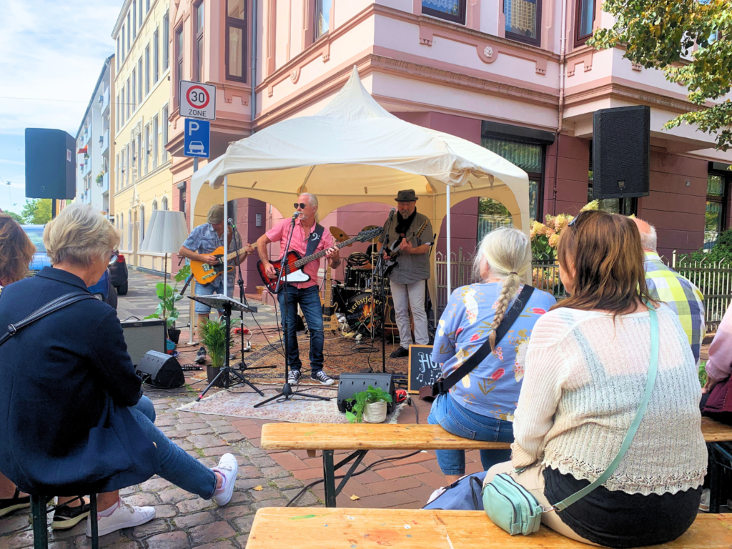 Menschen spielen Musik unter einem kleinen Pavillon auf offener Straße