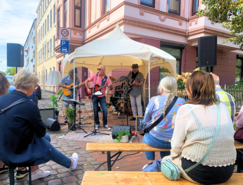 Menschen spielen Musik unter einem kleinen Pavillon auf offener Straße