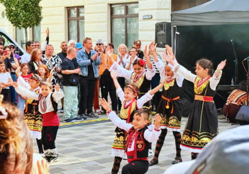 Eine bulgarische Tanzgruppe post inmitten einer Menschenmenge